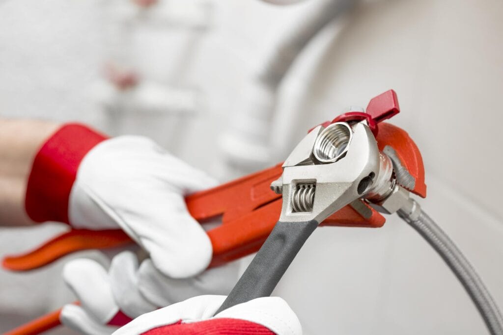 Plumber holding pipe wrenches for an emergency repair in Jupiter